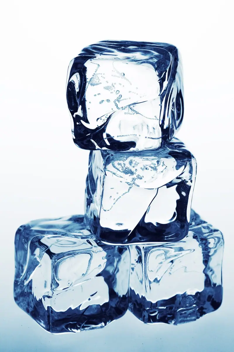 Clear ice cubes stacked on a white background
