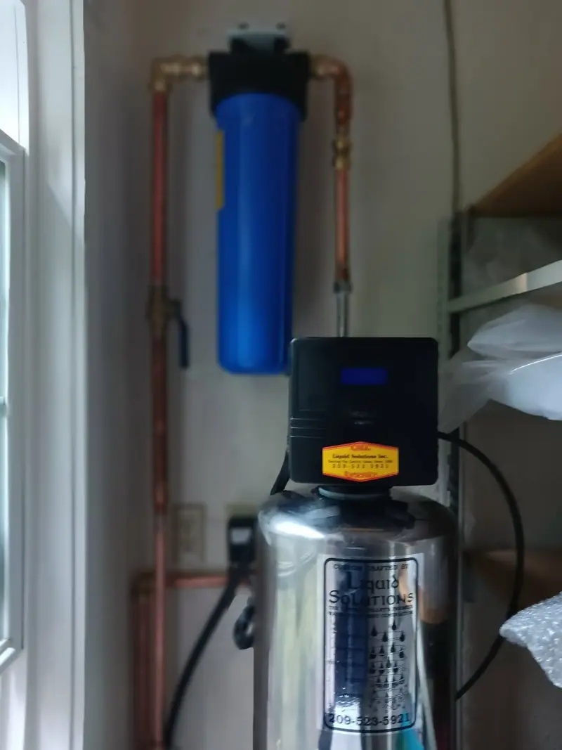 Stainless water softener and Big Blue whole house water filter installed by Liquid Solutions Inc