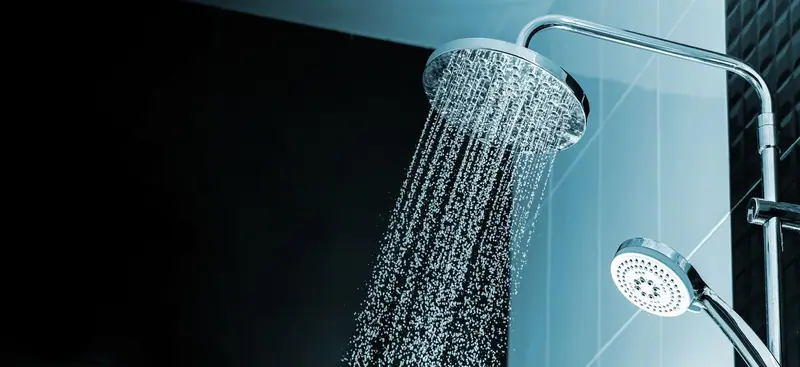 Water spraying from a rain shower head in a modern bathroom