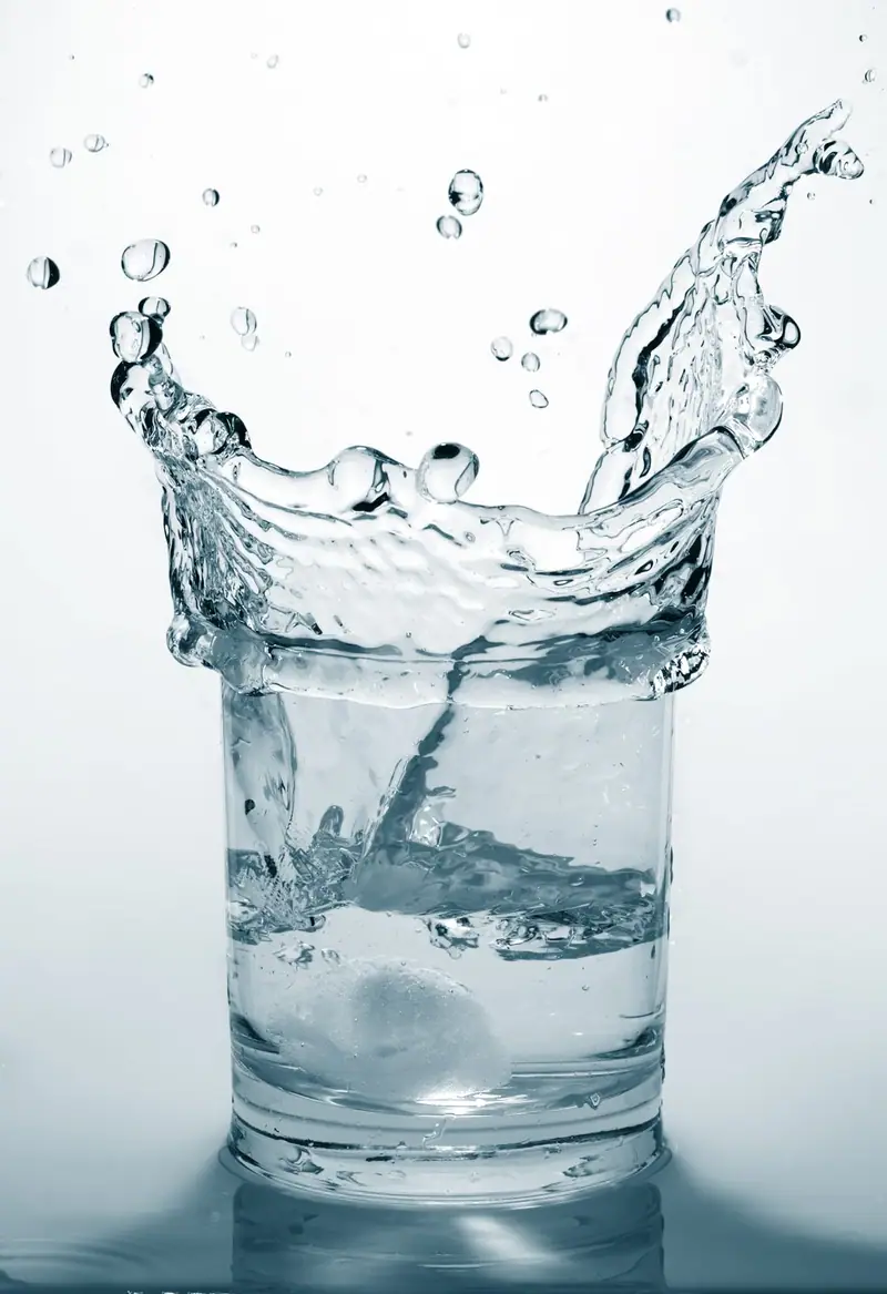 Clear water splashing in a drinking glass